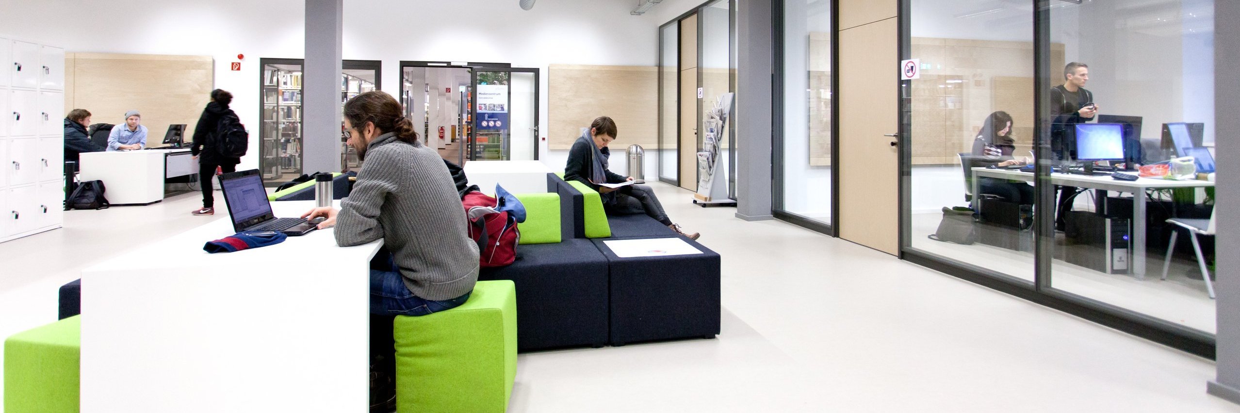 Blick ins Lernzentrum der h_da mit offenen und geschlossenen Lern- und Arbeitsbereichen und direkt angeschlossener Bibliothek